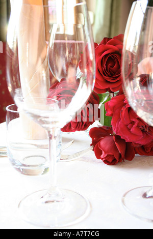 Stem glasses and bunch of roses on table Stock Photo