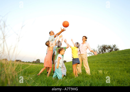 Family playing basketball in field