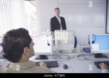 Rear view of businessman working on computer Stock Photo