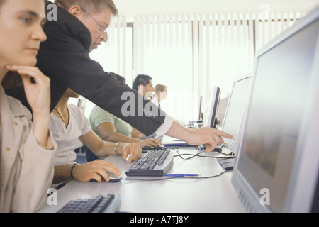 Side profile of businesspeople working on computers Stock Photo