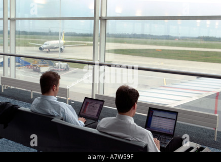 Men with laptop computers in airport lounge Stansted London Stock Photo