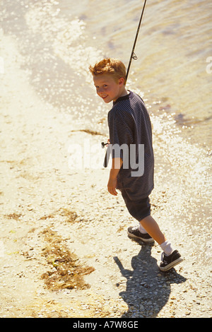 https://l450v.alamy.com/450v/a7w8ge/portrait-of-red-headed-10-year-old-boy-walking-with-a-fishing-rod-a7w8ge.jpg