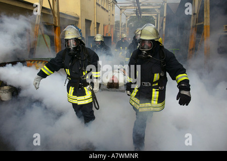 Fire fighters rescue a man during an exercice practice Stock Photo