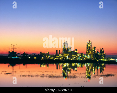 Israel Ashfela region Ramla Nesher cement factory large view at dusk with colourful sky artificial lifghts and reflection in pon Stock Photo