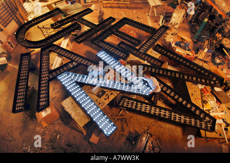 A pile of giant letters being fitted with lights by electricians Stock Photo