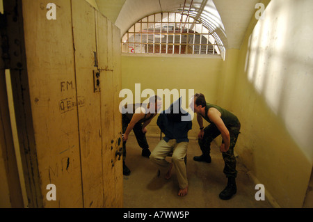 Two thugs question a hooded prisoner in a scene from a Pinter play ...