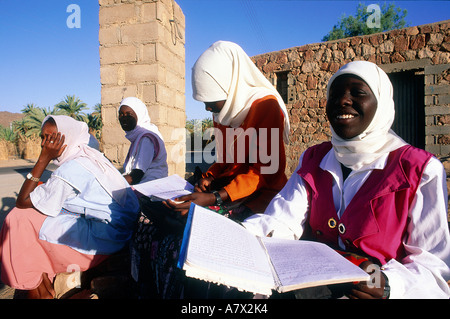 Algeria, Sahara area, Tassili N'Ajjer, Djanet oasis, young Tuareg schoolgirls waiting for the school bus Stock Photo