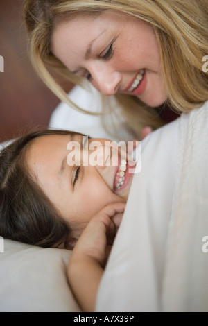 mother putting child to bed, joking with daughter, closeup Stock Photo