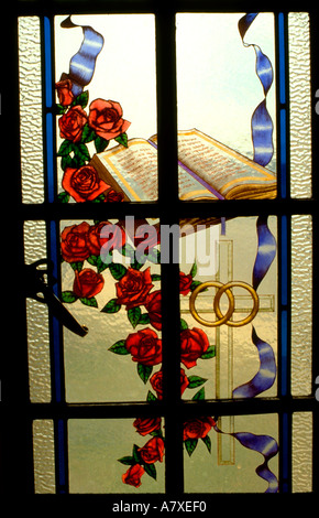 Wedding rings Bible cross and  flowers on stained glass window. Ft Snelling State Park Minnesota USA Stock Photo