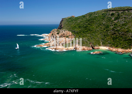 A catamaran sails through 'The Heads', the entrance to the Knysna lagoon on the Garden Route in South Africa. Stock Photo
