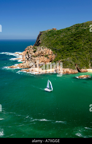 A catamaran sails through 'The Heads', the entrance to the Knysna lagoon on the Garden Route in South Africa. Stock Photo