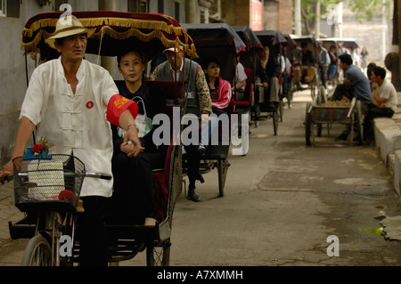 Chinese rickshaws driving through the narrow streets in Hutong (old ...