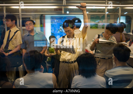 Asia, China, Shanghai, Passengers on crowded Metro subway train during evening rush hour near People's Square Station Stock Photo