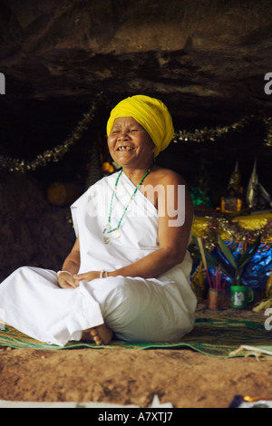 Female Buddhist leader and animist ascetic laughing in her cave above Ban Mai Singsamphan, Laos Stock Photo