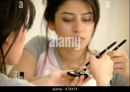Woman applying make-up Stock Photo