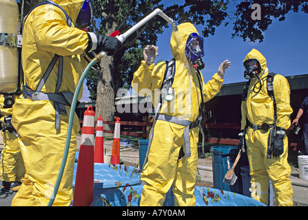 Hazmat team washes member in decontamination line. Stock Photo