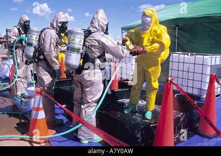 Hazmat team washes member in decontamination line. Stock Photo