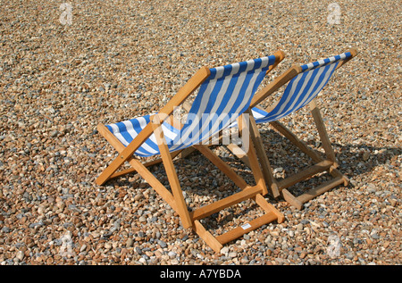 Two deck chairs empty on Brighton beach Stock Photo