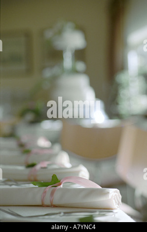 A table set for a wedding breakfast with the cake in background Stock Photo