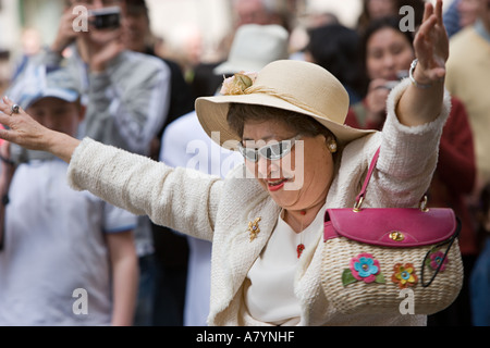 Asian woman dances on 5th Avenue during New York City's Easter Parade Stock Photo