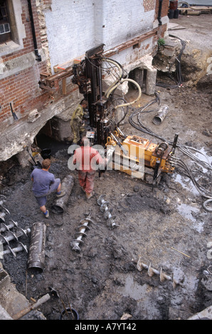Cambridge small diameter cased bored piles being installed alongside existing building in mud close to river Cam Stock Photo