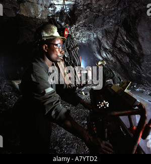 Mining operations for transporting, managing & the processing of gold ore. Miners drilling for rock core samples at underground gold mine in Ghana Stock Photo