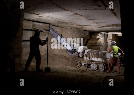 Engineers starting to cut limestone rock face for extracting blocks of stone at Chilmark underground quarry Chilmark Wiltshire England UK Stock Photo