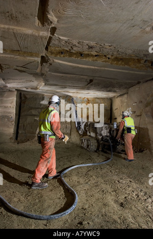 Engineers starting to cut limestone rock face for extracting blocks of stone at Chilmark underground quarry Chilmark Wiltshire England UK Stock Photo