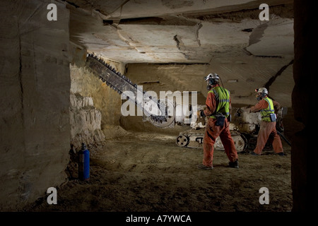 Engineers starting to cut limestone rock face for extracting blocks of stone at Chilmark underground quarry Chilmark Wiltshire England UK Stock Photo