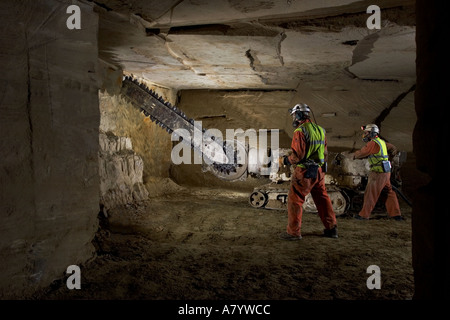 Engineers starting to cut limestone rock face for extracting blocks of stone at Chilmark underground quarry Chilmark Wiltshire England UK Stock Photo