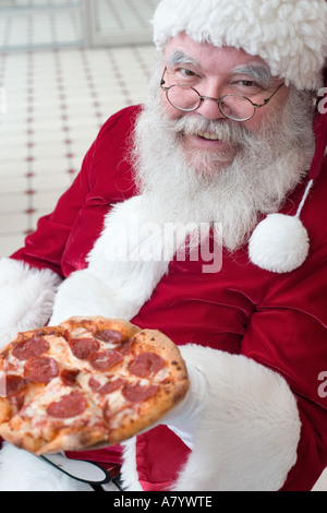Santa Claus eating pizza Stock Photo