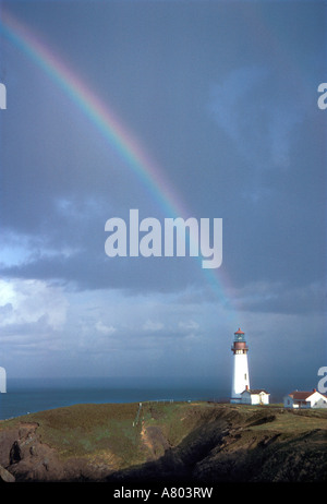 A rainbow hangs above the Yaquina Lighthouse, on Yaquina Head, above the Pacific Ocean near Newport, on the Oregon Coast. Stock Photo