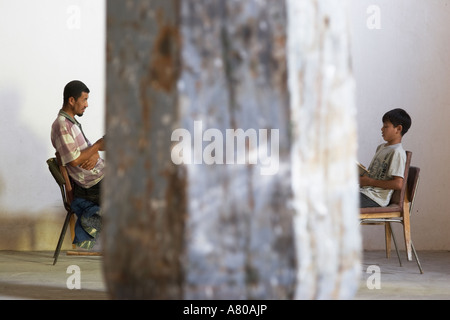 Uzbekistan, Man And Boy Reading In Mosque Stock Photo