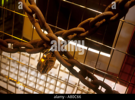 Computer secured by chains and padlock inside a metal cage Stock Photo