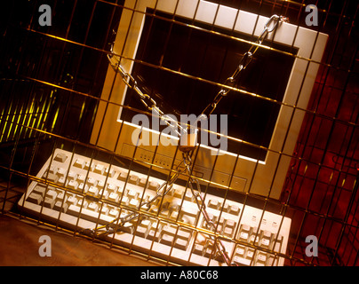 Computer secured by chains and padlock inside a metal cage Stock Photo