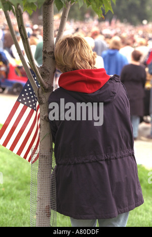 Thoughtful woman age 30 with flag at Minnesota Remembers Memorial Service at state capitol for 9/11. St Paul Minnesota MN USA Stock Photo