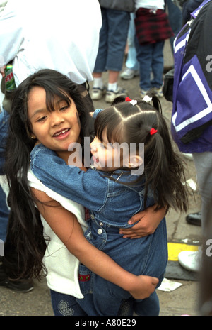 Sisters ages 6 and 4 having fun at Cinco de Mayo parade. St Paul Minnesota USA Stock Photo