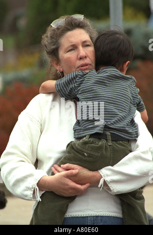 Woman age 40 holding boy age 3 at Cinco de Mayo festival. St Paul Minnesota USA Stock Photo