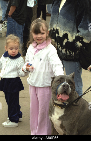 Two girls ages 5 and 2 with dog at Cinco de Mayo festival. St Paul Minnesota USA Stock Photo