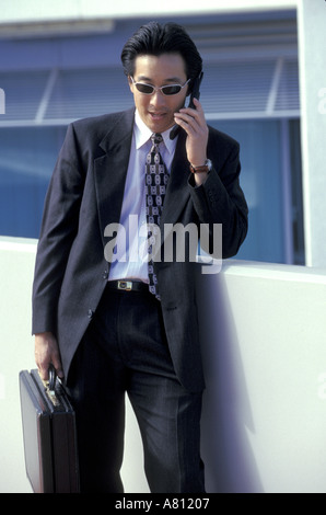 Australia Qld Brisbane businessman holding attache case talking on cell phone Stock Photo