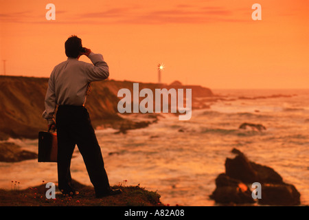 Businessman talking on cellphone near Point Arena Lighthouse on California coast Stock Photo