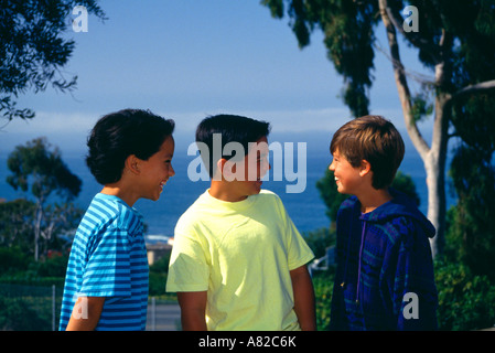 young person people Three young boys 11-13 year olds old hang hanging out park on hillside overlooking ocean US USA America Myrleen Pearson Stock Photo