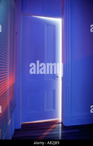 Blue light shining through half open door Stock Photo