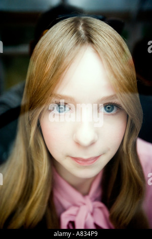 Portrait of a young woman with her lips and nose pressed against a transparent glass Stock Photo