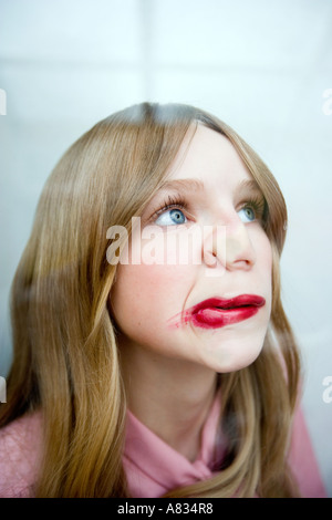 Portrait of a young woman with her lips and nose pressed against a transparent glass, her lipstick smudged. Stock Photo