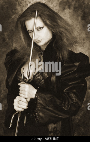 Goth Woman Wearing a Spider Necklace Leather Coat and Holding Two Daggers