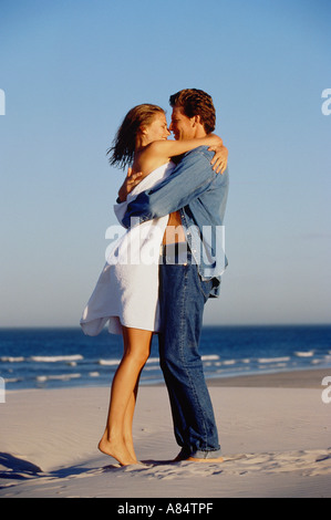 Happy couple embracing on sunny beach. Stock Photo