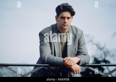 Outdoor portrait of young man standing on park bridge. Stock Photo