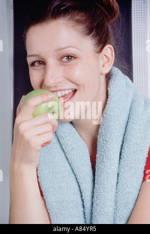 Indoor close-up of young woman eating an apple. Stock Photo