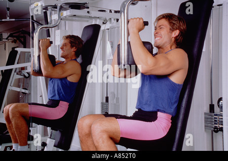 Young man exercising using gymnasium equipment. Stock Photo